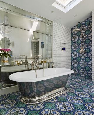patterned tile bathroom with open style shower and freestanding bath and mirrored wall from Drummonds