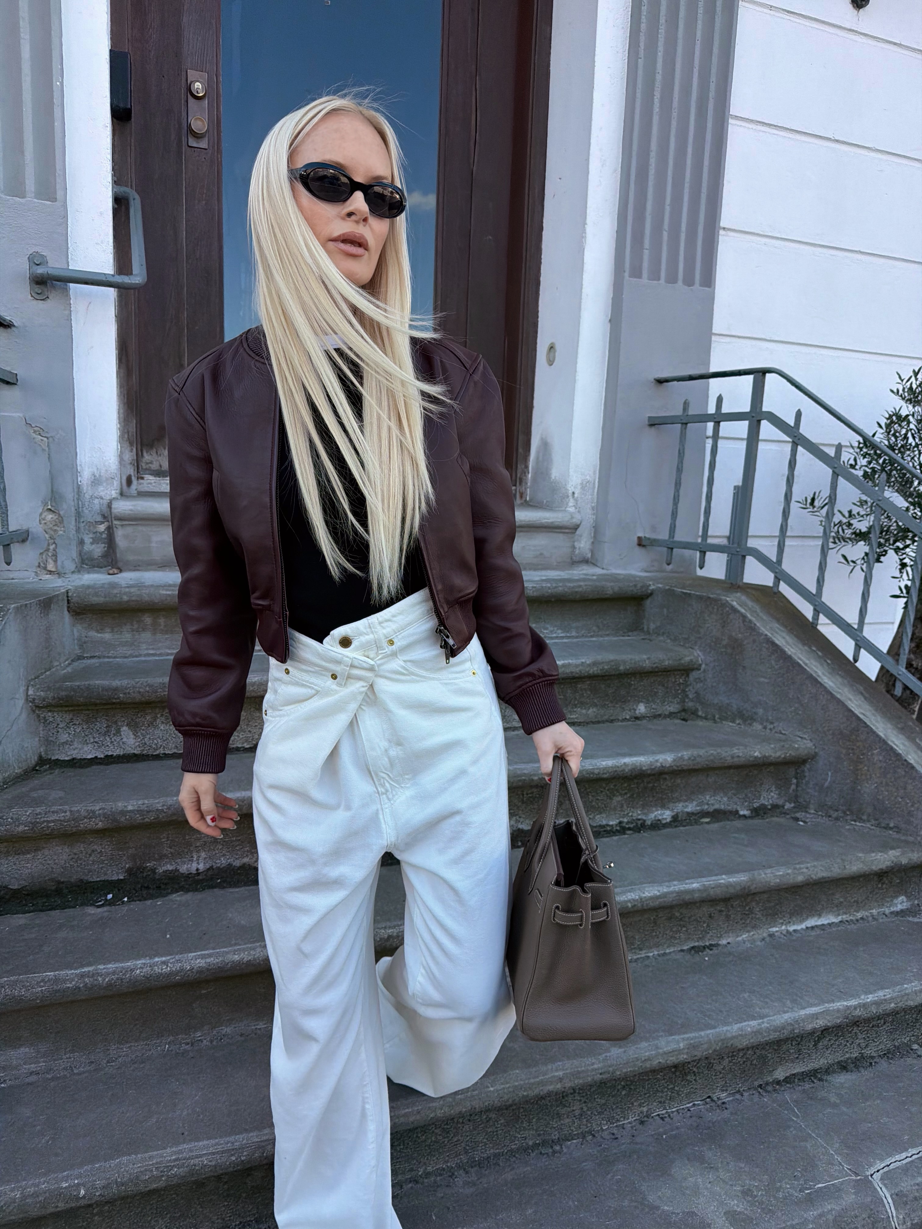 Thora Valdimars wearing a black t-shirt, leather jacket and white jeans.