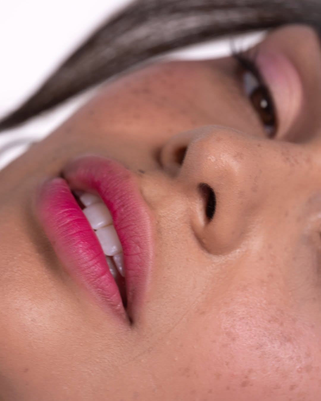 a woman with watercolor makeup trend a close up of her lips with a berry-toned lip tint