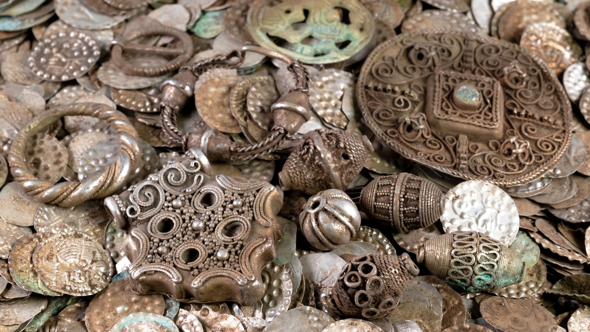 a pile of silver coins and jewelry