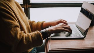 Single woman using laptop at desk