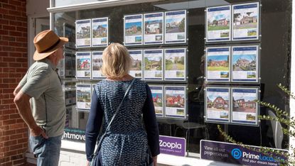 A couple looking at an estate agent's window