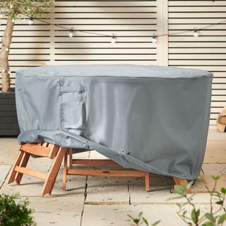 Grey cover protecting wooden furniture on patio