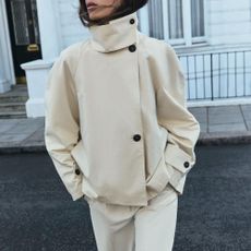 Woman wears minimalist Zara trench coat crossing the street for autumn 2026