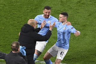 Phil Foden celebrates (right) his crucial goal with manager Pep Guardiola (left)