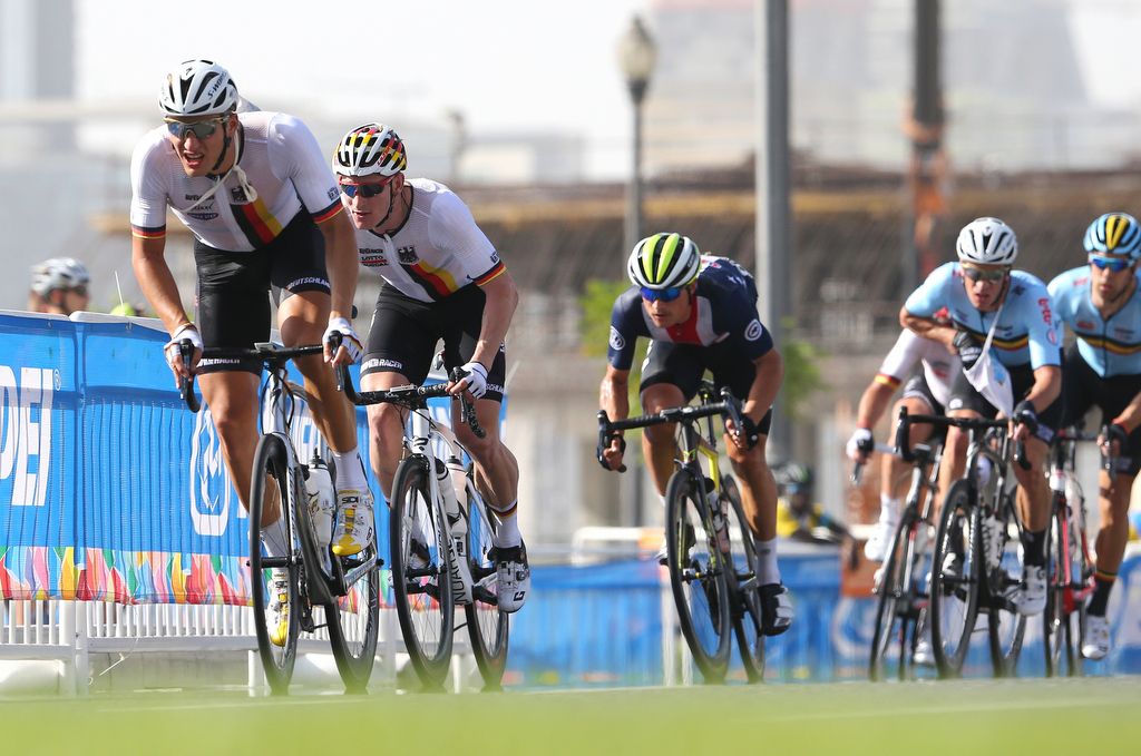 Marcel Kittel, with a musette over his shoulder, working for teammate Andre Greipel (Germany)