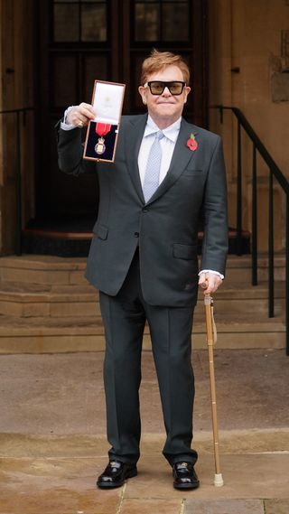 Sir Elton John collecting his OBE