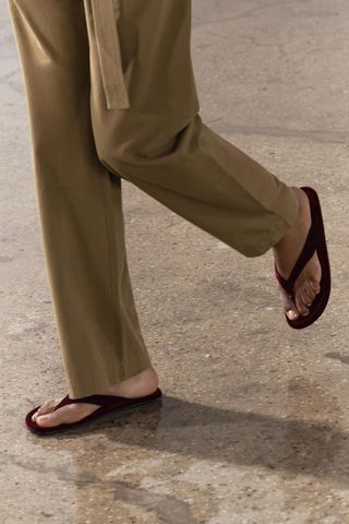 close up shot of Zara model wearing velvet flip flops