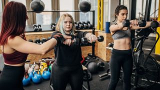 Women performing the front raise shoulder exercise