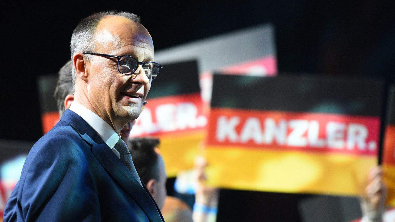 Friedrich Merz, seen at a rally in front of supporters waving placards