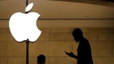 A man checks his phone in an Apple store © Drew Angerer/Getty Images