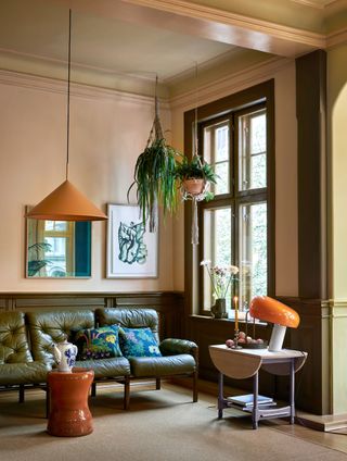 a living room in khaki green and pink, with orange accents