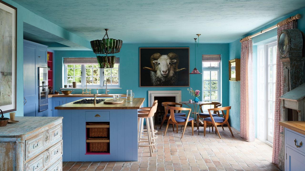 how to use the colour wheel, turquoise farmhouse style kitchen with blue cabinets and island, terracotta tiles, vintage furniture, large ram artwork, dining area, bar stools