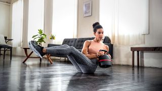 Fit young woman working out with the Bowflex Selecttech 840 kettlebell