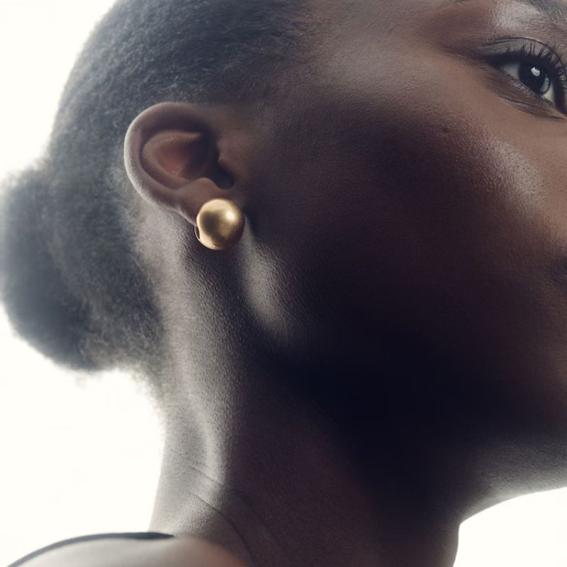 Polished Ball Huggie Earrings in Gold Tone on model