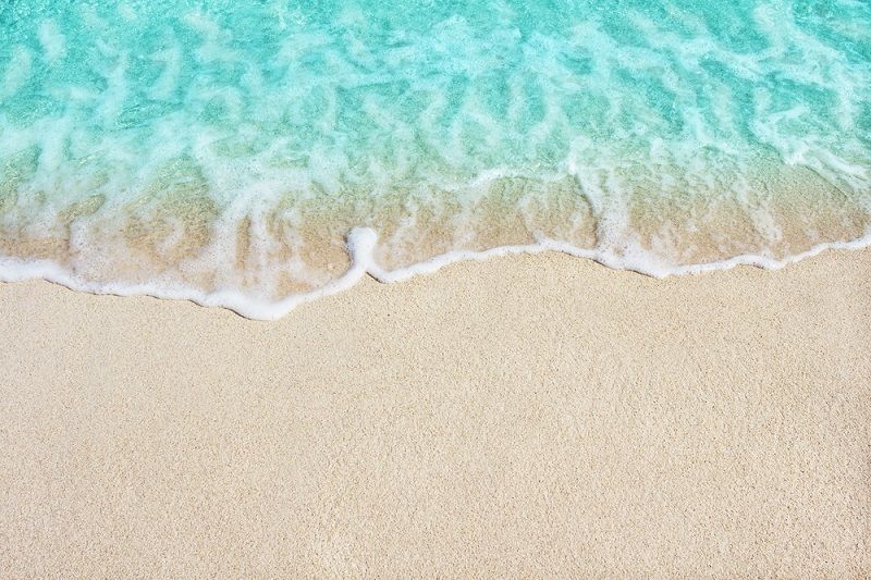 An ocean wave over sand.