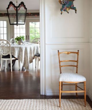 entryway with cream walls, cream textured rug and wooden chair