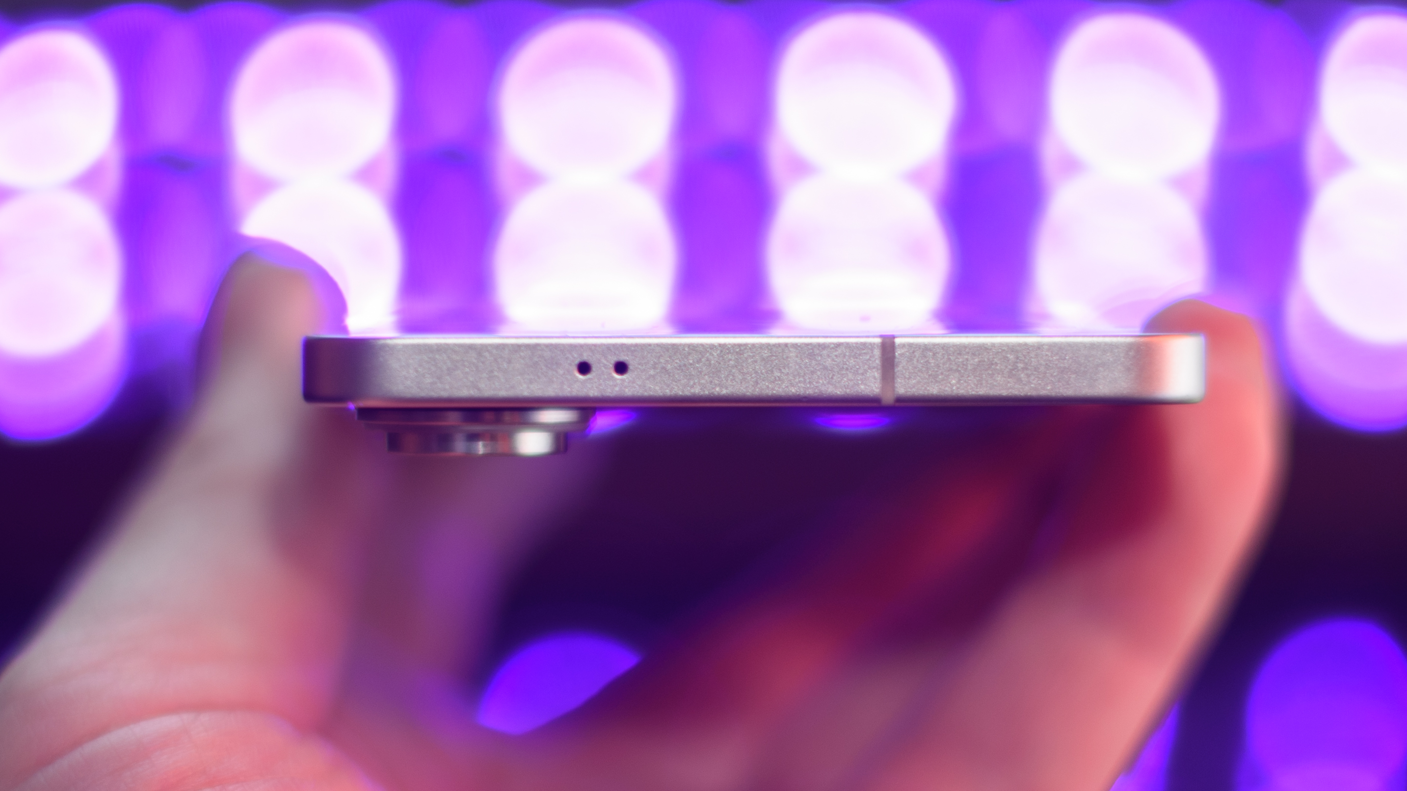 Samsung Galaxy S25 Edge from the top with black lights blurred in the background