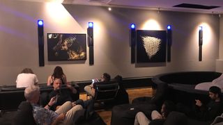L-Acoustics showroom with people sitting, in low lighting