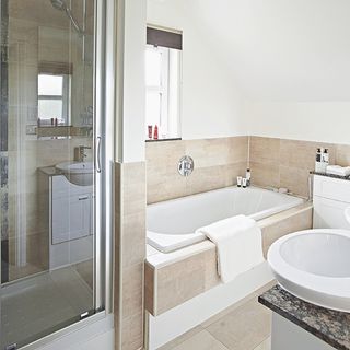 bathroom with bathtub and shower with white wall