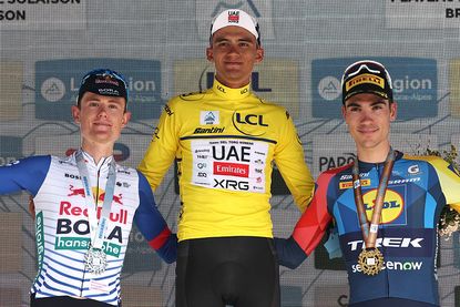 (From L) Overall second-placed Red Bull - Bora - Hansgrohe's Australian rider Luke Tuckwell, overall winning UAE Team Emirates XRG's Mexican rider Isaac Del Toro Romero wearing the overall leader's yellow jersey and third-placed Lidl-Trek's Spanish rider Juan Ayuso celebrate on the podium after the 8th and final stage of the Tour Auvergne-Rhone-Alpes cycling race (formerly known as the Criterium du Dauphine), 120,1km between Beaufort and Plateau de Solaison, in the French Alps on June 14, 2026. (Photo by Anne-Christine POUJOULAT / AFP)