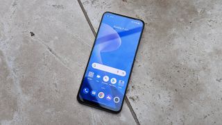 The Realme 9 lying face up on a tiled floor