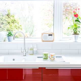 kitchen with white window red and white counter and wash basin