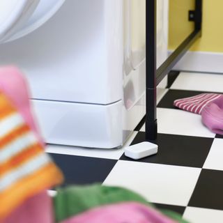 IKEA smart sensor on a chequered kitchen or bathroom floor
