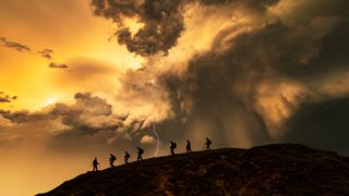 Hikers on the storm at sunset, Catbells Mountain, Lake District. UK