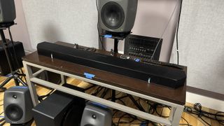 An early prototype of a Samsung soundbar photographed on a table surrounded by Genelec studio monitors