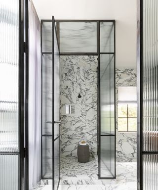 A black and white marble shower with fluted glass within a crittall frame