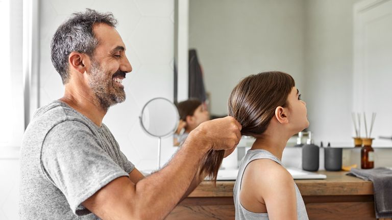 father doing daughter's hair 