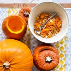 Pumpkins with pumpkin seeds scooped in a bowl