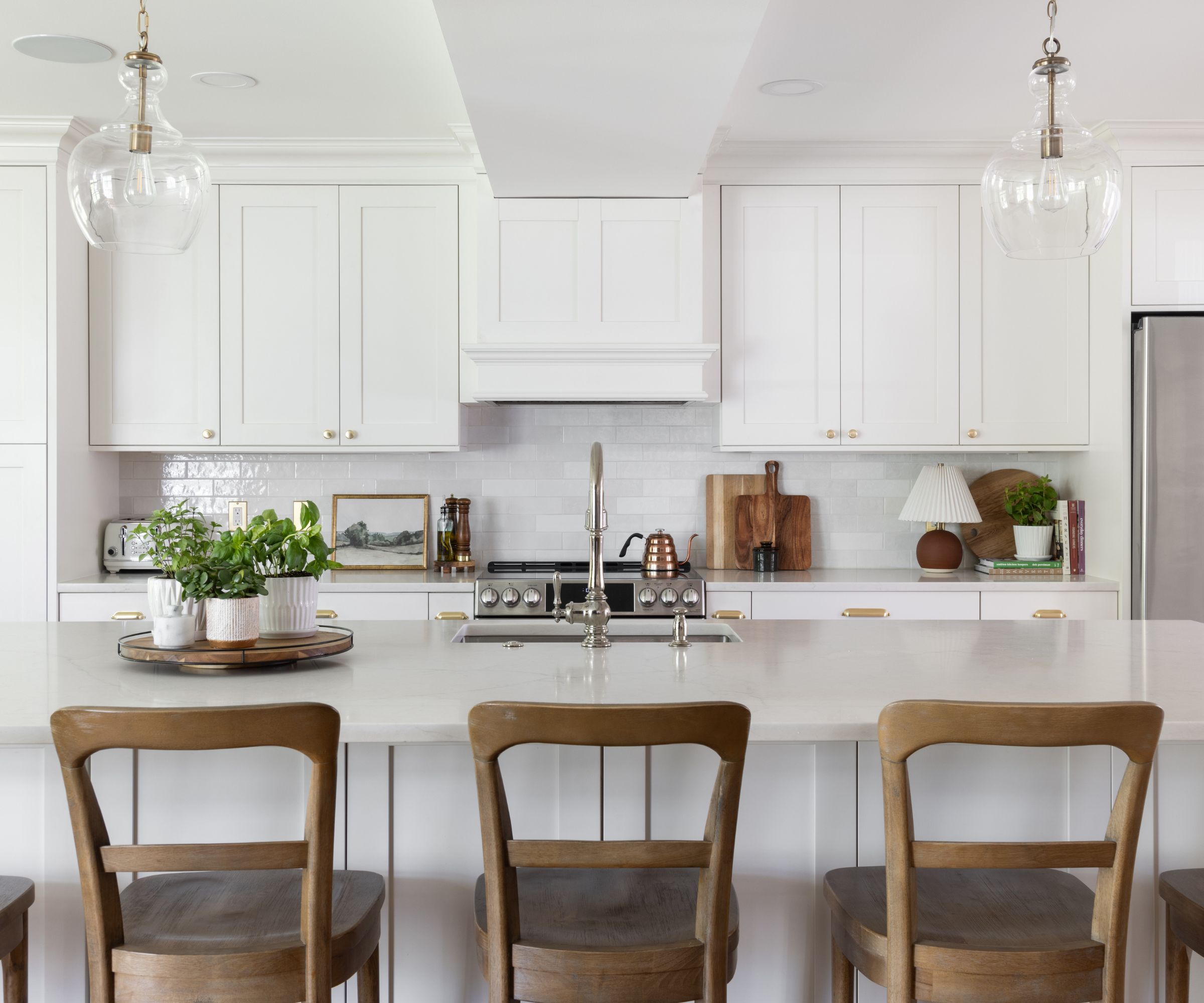 A white kitchen with wooden island seating and elevated essentials doubling as decor