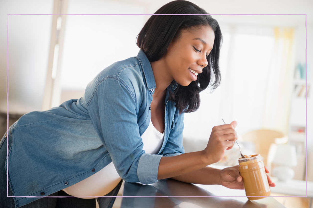 Pregnant women eating peanut butter from a jar 