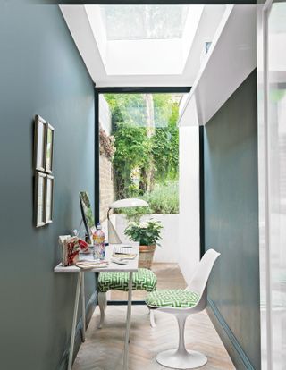 Home office with blue walls, white ceiling and floor-to-ceiling window