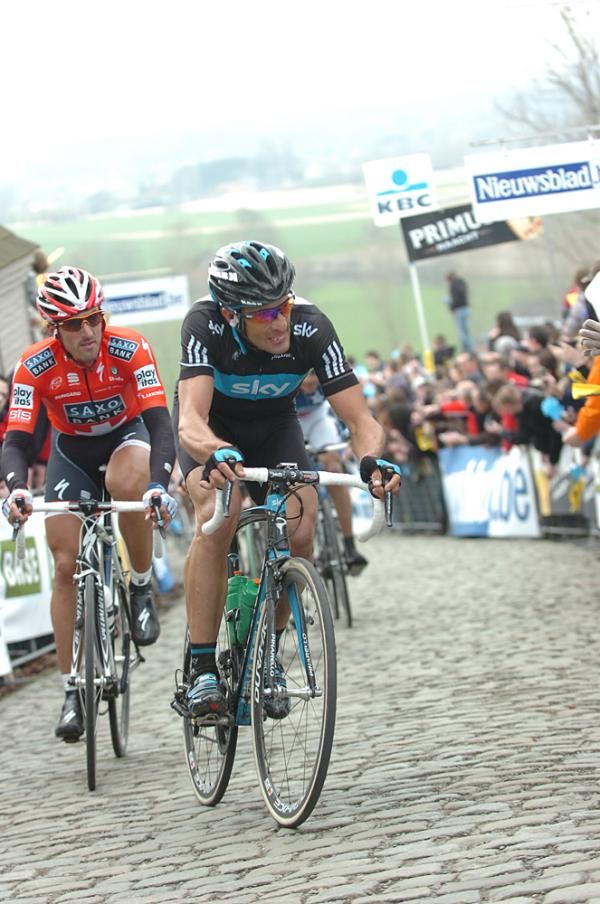 Juan Antonio Flecha (Sky) grits his teeth on the Paterberg while eventual winner Fabian Cancellara (Saxo Bank) appears unfazed by the cobbled climb.