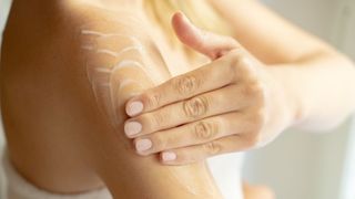 woman applying lotion to arm