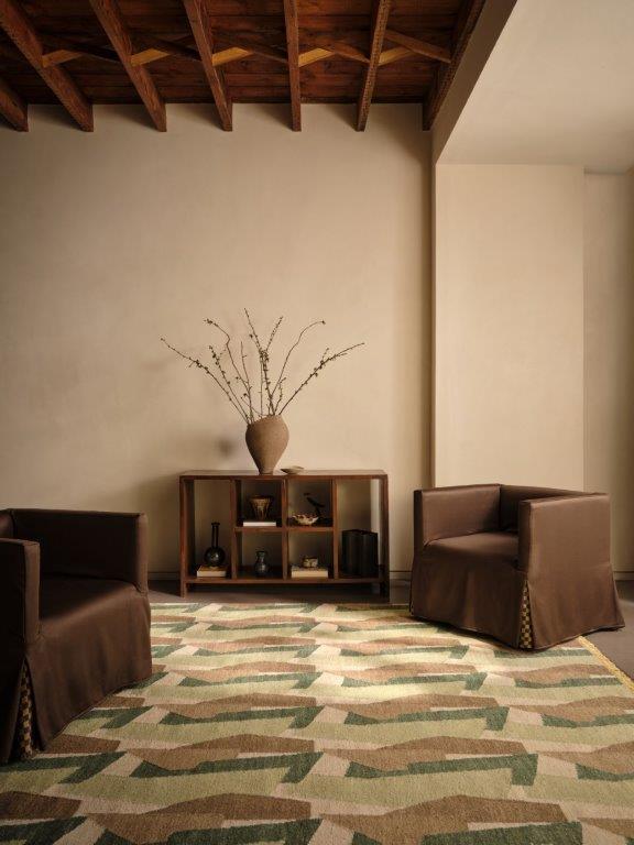 a geometric rug in a modern room with linen chairs and limewash walls