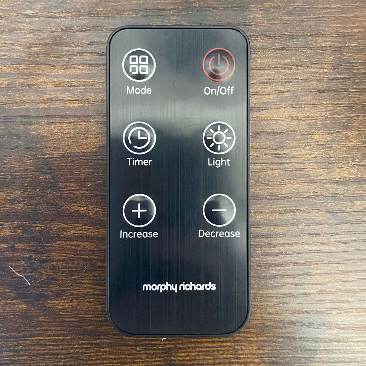 Remote control of the Morphy Richards HeatFlux 1.5kW Ceramic Fan Heater on a wooden surface