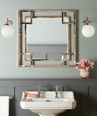 Simple bathroom elevated with two wall sconces on either side of the bathroom mirror
