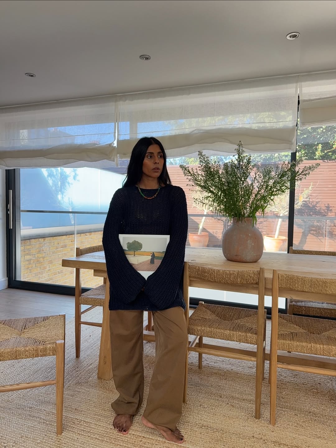 @monikh wears brown trousers navy jumper