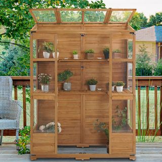 wooden walk-in greenhouse on a deck