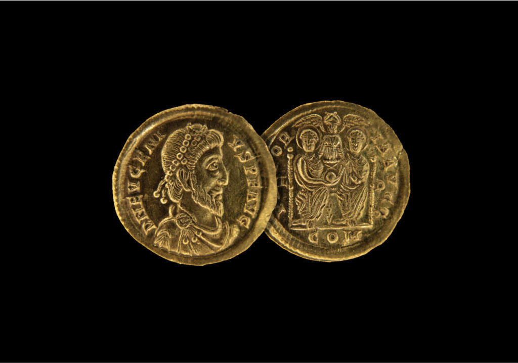 Two sides of a gold coin on a black background