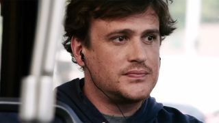 Jason Segel, sitting on a bus and listening to headphones with a cord in Jeff, Who Lives At Home.