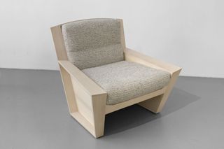 A wooden armchair with light gray upholstery