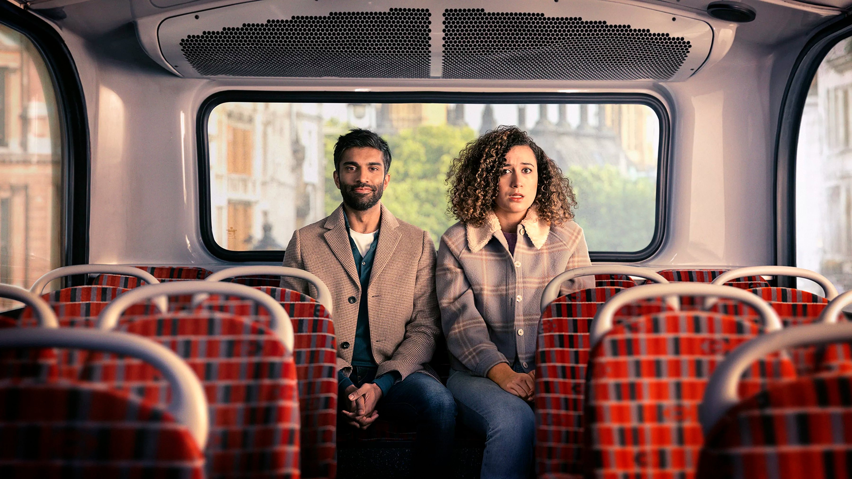 Rose Matafeo og Nikesh Patel sidder ved siden af hinanden i en tom bus