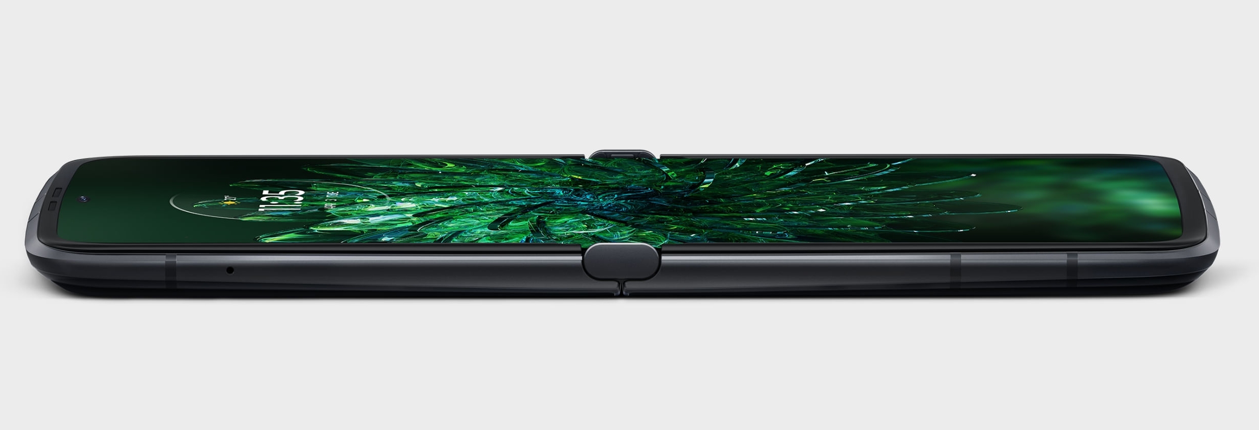 The Motorola Razr 2022 lying flat and open with a green wallpaper