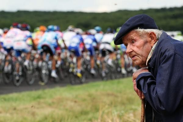 A specator watches the peloton roll by en route to Saint-Fargeau.