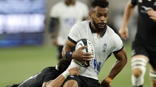 Fijian Waisea Nayacalevu is tackled with the rugby ball in his hands.